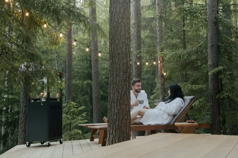Pärchen entspannt auf einer Holzterrasse im Wald – romantische Retreat-Location in der Natur als Raum-Partner bei Retreat Hero